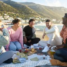 Grupo de amigos comiendo en la playa, Sudáfrica