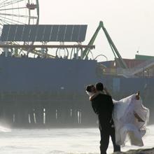 Pareja de recién casados con el muelle de Santa Mónica al fondo, California, Estados Unidos